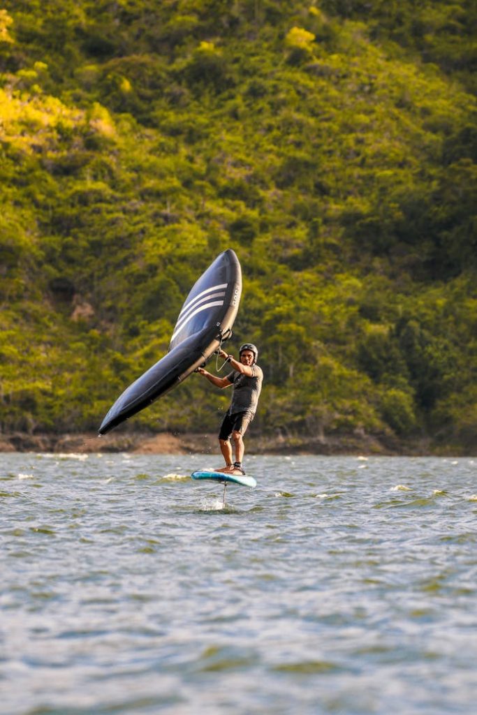 Man enjoying thrilling wingfoiling action on the ocean, gliding with the wing sail.